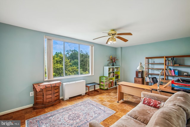 office featuring baseboards, ceiling fan, and radiator
