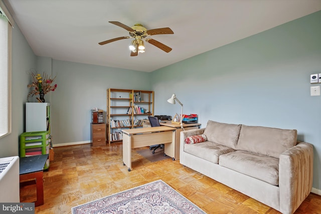 office area with ceiling fan and baseboards