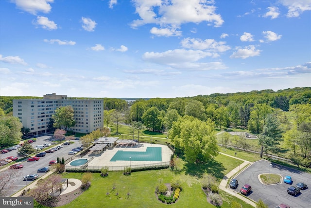 aerial view of a pool area and a heavily wooded area