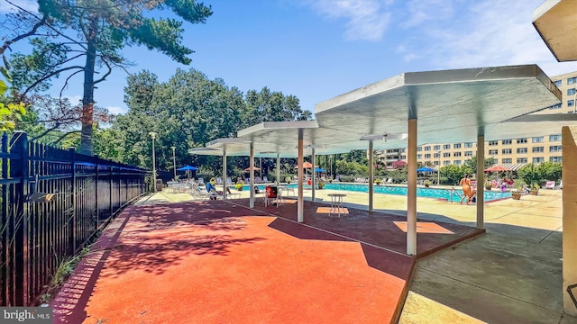 view of community with a pool, fence, and a patio area