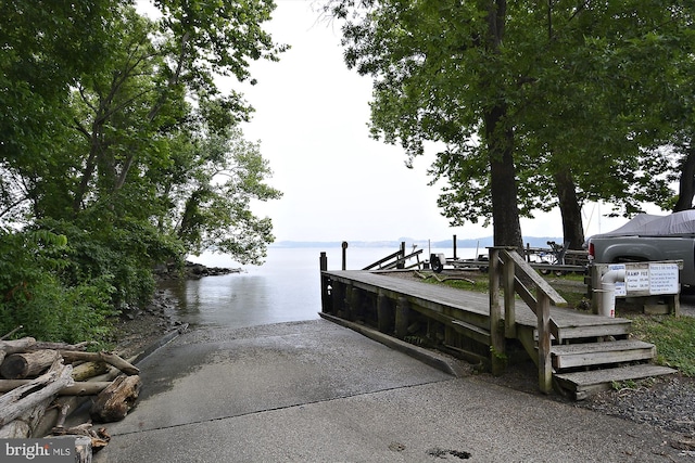 view of home's community featuring a boat ramp, a water view, and a dock