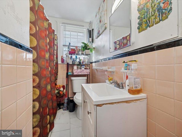 bathroom featuring tile walls, toilet, marble look tiles, vanity, and a shower with shower curtain