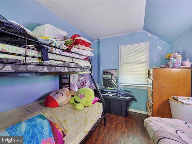 bedroom featuring lofted ceiling, wood finished floors, and baseboards