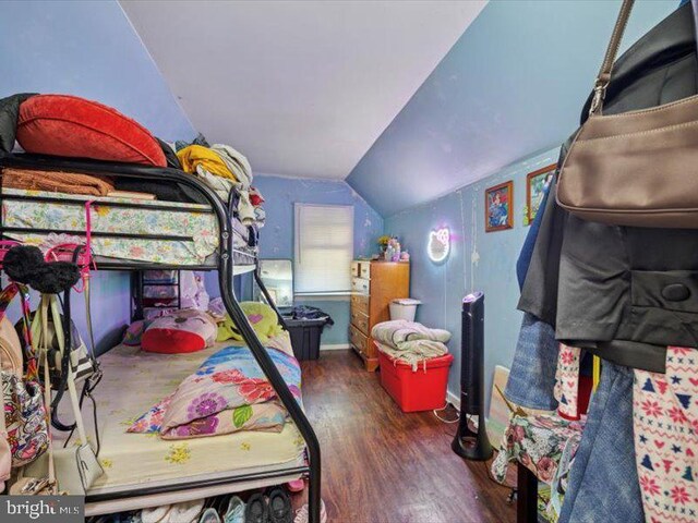 bedroom featuring wood finished floors and lofted ceiling