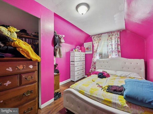 bedroom featuring lofted ceiling, wood finished floors, and baseboards