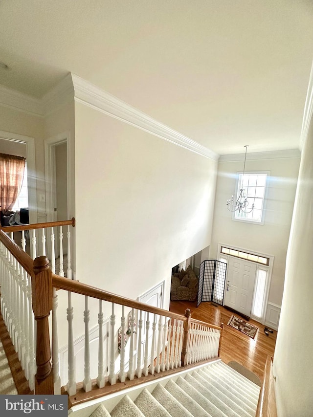 16335 Admeasure Cir, Woodbridge, VA 22191 - stairway with a chandelier, ornamental molding, and wood finished floors