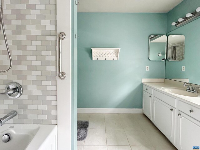 bathroom featuring tile patterned floors, vanity, baseboards, and shower / washtub combination