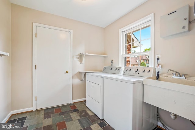 washroom featuring separate washer and dryer, baseboards, and stone finish floors