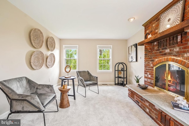 living area with baseboards, light carpet, and a fireplace