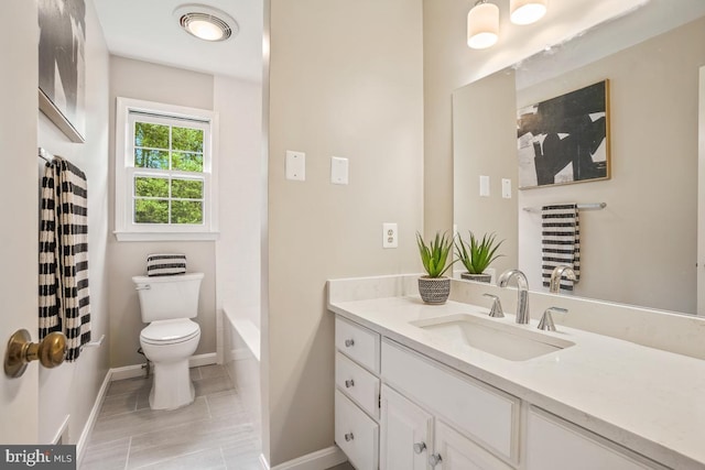 bathroom featuring toilet, baseboards, and vanity
