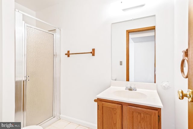 bathroom with a shower stall, vanity, baseboards, and tile patterned flooring