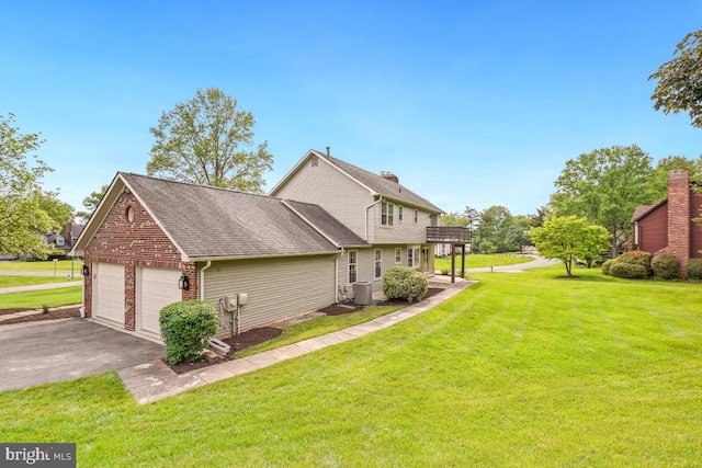 view of home's exterior with central AC unit, a lawn, an attached garage, driveway, and a shingled roof