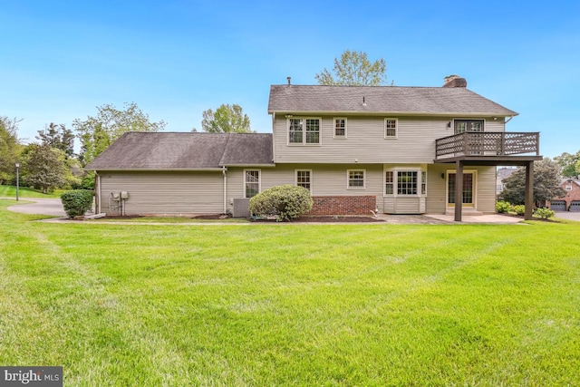back of house with a patio area, a chimney, a lawn, a wooden deck, and central air condition unit