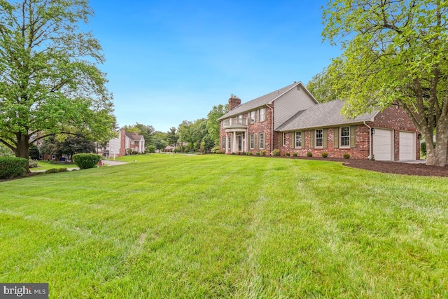 view of green lawn with an attached garage