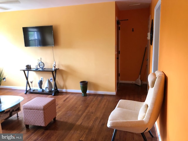sitting room with baseboards and wood finished floors