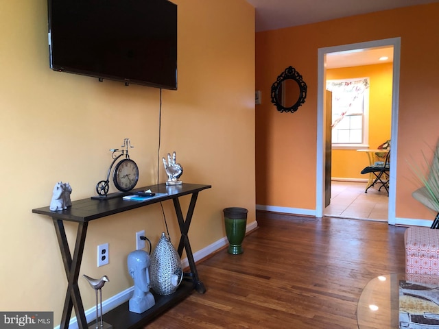 hall featuring wood finished floors and baseboards