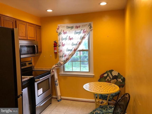 kitchen with appliances with stainless steel finishes, brown cabinetry, recessed lighting, light tile patterned floors, and baseboards