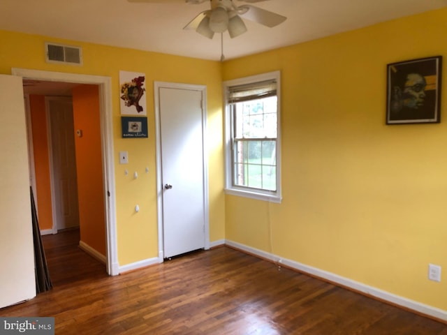 unfurnished room with ceiling fan, dark wood-style flooring, and baseboards