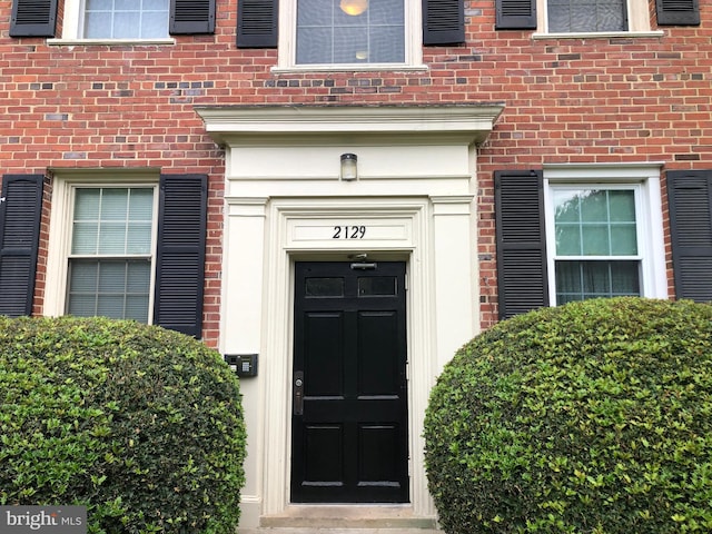 entrance to property featuring brick siding