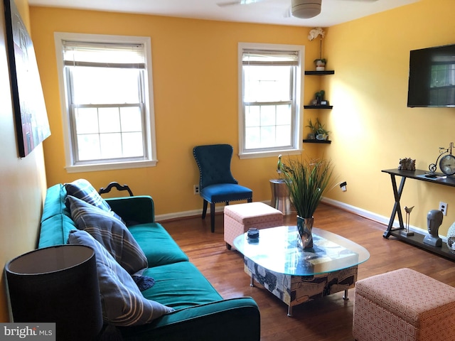 living area with wood finished floors, ceiling fan, and baseboards
