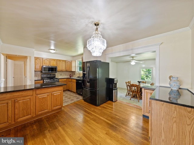 5403 Rolling Rd, Springfield, VA 22151 - kitchen with black appliances, a sink, wood finished floors, healthy amount of natural light, and ornamental molding