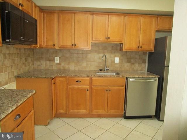 718 Quince Orchard Blvd Unit 718, Gaithersburg, MD 20878 - kitchen featuring stainless steel appliances, a sink, light stone counters, light tile patterned flooring, and tasteful backsplash