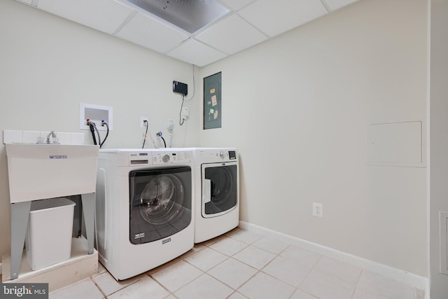 clothes washing area featuring independent washer and dryer, electric panel, baseboards, and light tile patterned flooring