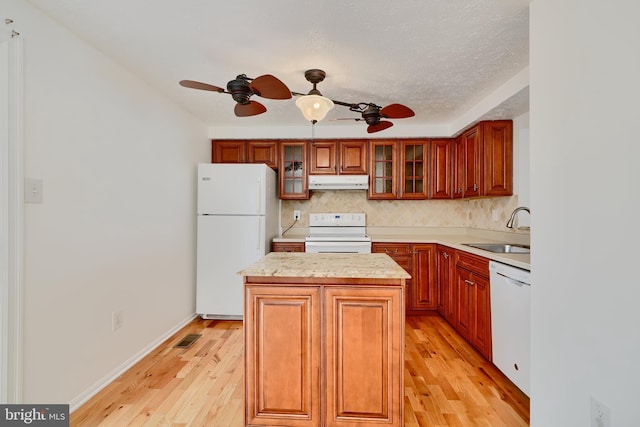 kitchen featuring white appliances, a sink, under cabinet range hood, ceiling fan, and a textured ceiling