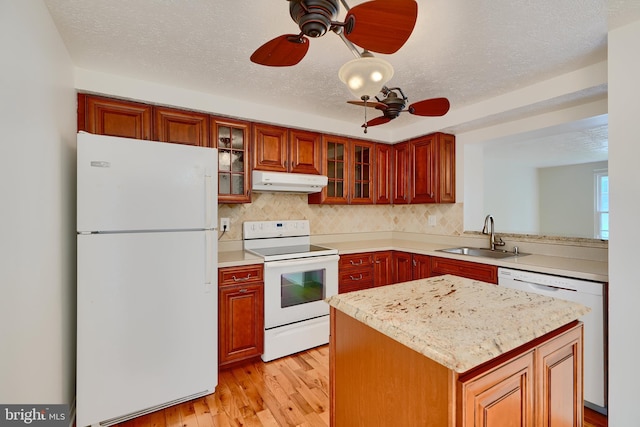 kitchen featuring white appliances, a sink, under cabinet range hood, a ceiling fan, and light wood-style floors