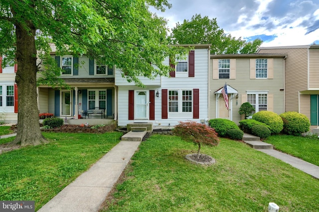 multi unit property featuring a front lawn and covered porch