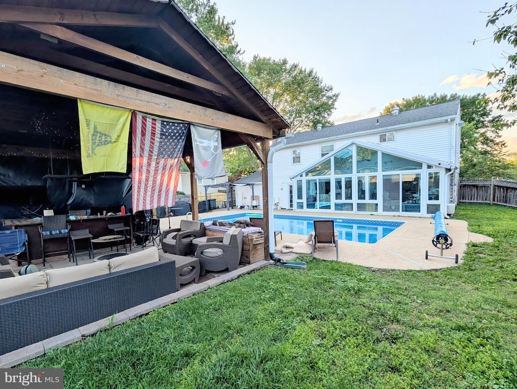 view of swimming pool with outdoor lounge area, a patio, and a sunroom