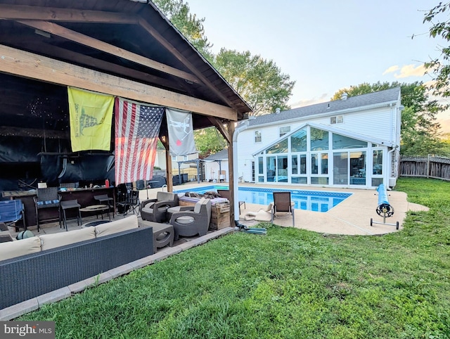 view of swimming pool with outdoor lounge area, a patio, and a sunroom