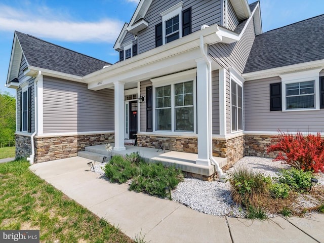16016 Ambleside Ct, Hughesville, MD 20637 - view of exterior entry featuring covered porch, stone siding, and roof with shingles