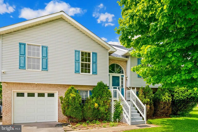 115 Emmitsburg Rd, Thurmont, MD 21788 - split foyer home featuring a garage, brick siding, driveway, and a front lawn
