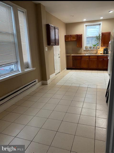 4400 N Franklin St, Philadelphia, PA 19140 - kitchen with a baseboard heating unit, light countertops, baseboards, light tile patterned floors, and recessed lighting
