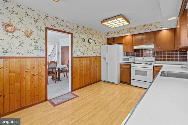 8046 Fairview St, Philadelphia, PA 19136 - kitchen with white appliances, under cabinet range hood, wainscoting, light wood finished floors, and a sink