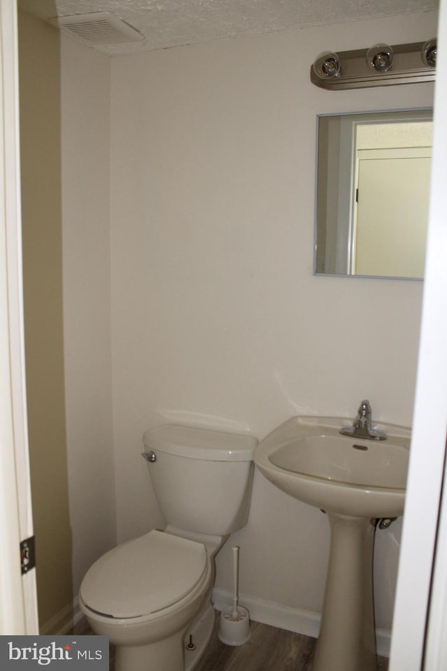 8323 Revelation Ave, Walkersville, MD 21793 - half bathroom featuring toilet, baseboards, and wood finished floors