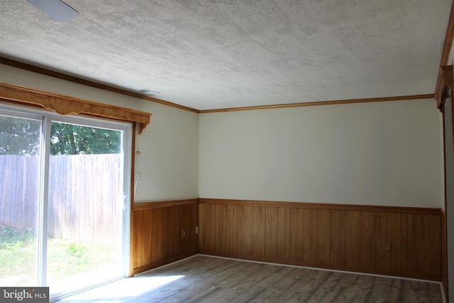 8323 Revelation Ave, Walkersville, MD 21793 - empty room featuring wood finished floors, wainscoting, a textured ceiling, ornamental molding, and wooden walls