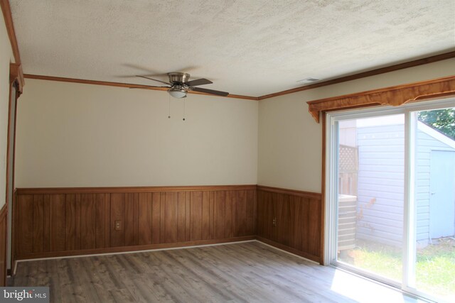 8323 Revelation Ave, Walkersville, MD 21793 - spare room featuring a ceiling fan, wood finished floors, a textured ceiling, a wainscoted wall, and ornamental molding