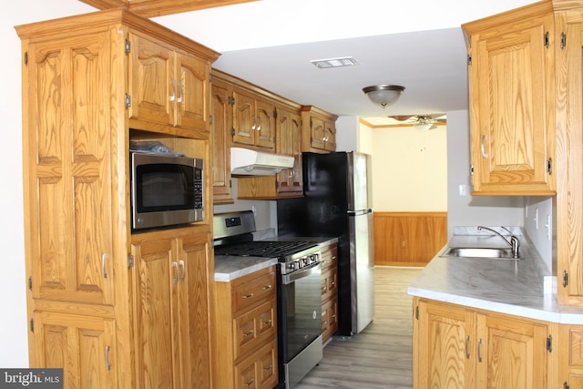 8323 Revelation Ave, Walkersville, MD 21793 - kitchen with stainless steel appliances, a sink, under cabinet range hood, light countertops, and light wood-style flooring