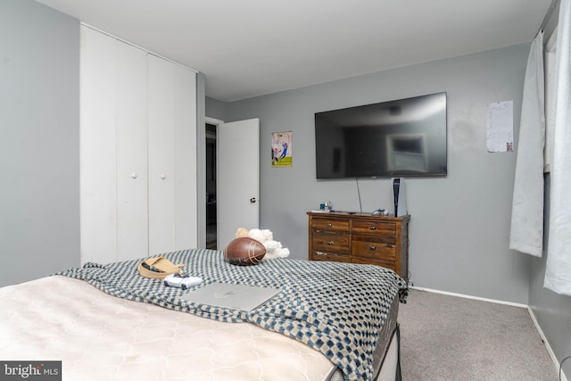 carpeted bedroom featuring a closet and baseboards