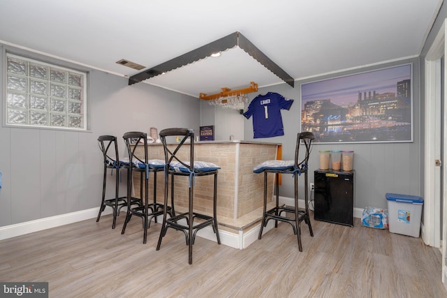 indoor bar featuring wood finished floors and baseboards