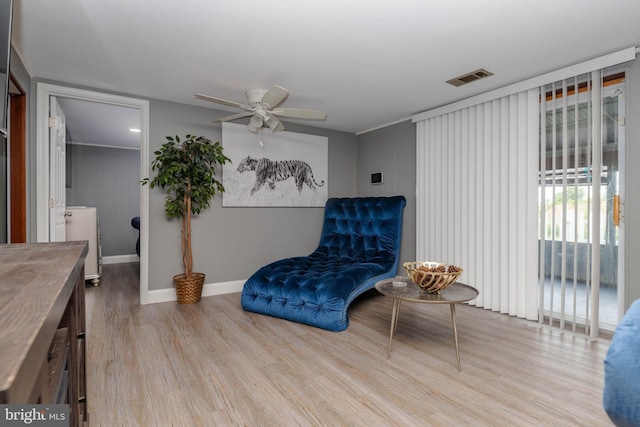 sitting room with ceiling fan, wood finished floors, and baseboards