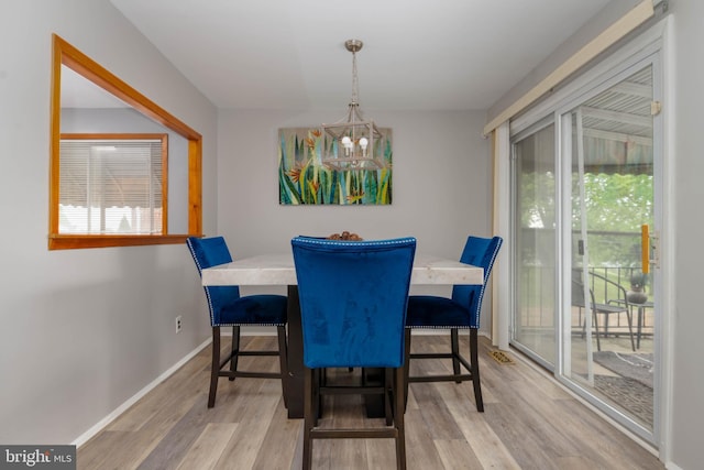 dining area featuring a chandelier, light wood finished floors, and healthy amount of natural light