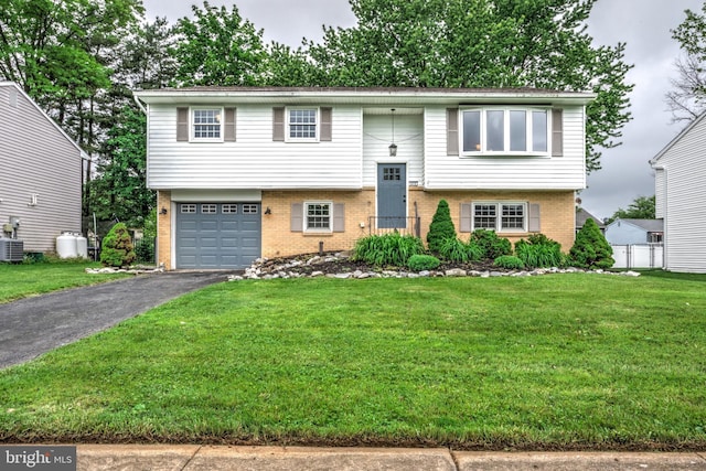 809 N Arch St, Mechanicsburg, PA 17055 - split foyer home featuring brick siding, asphalt driveway, a garage, and central air condition unit