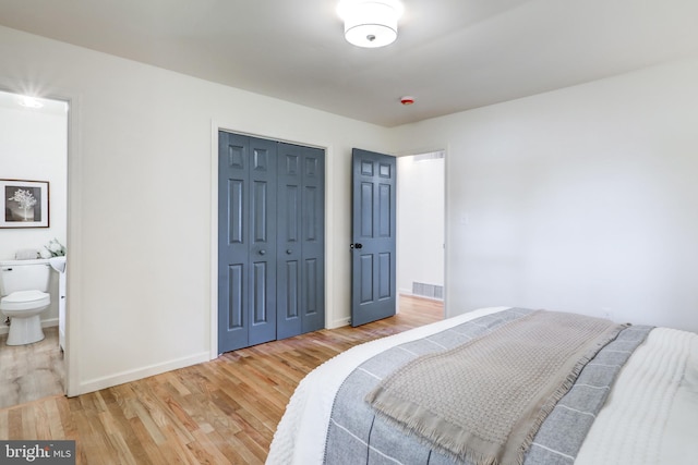 809 N Arch St, Mechanicsburg, PA 17055 - bedroom with light wood finished floors, a closet, baseboards, and connected bathroom