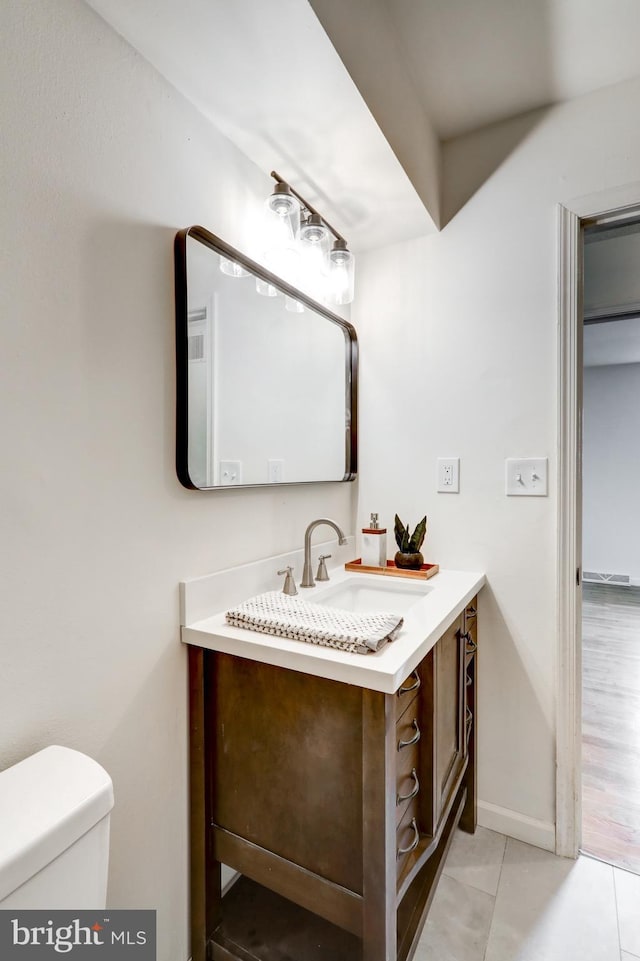 809 N Arch St, Mechanicsburg, PA 17055 - half bath with vanity, toilet, tile patterned flooring, and baseboards