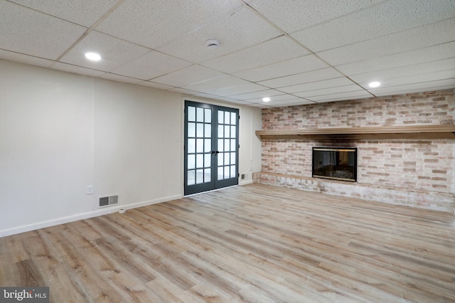 809 N Arch St, Mechanicsburg, PA 17055 - unfurnished living room with french doors, a paneled ceiling, wood finished floors, baseboards, and a brick fireplace