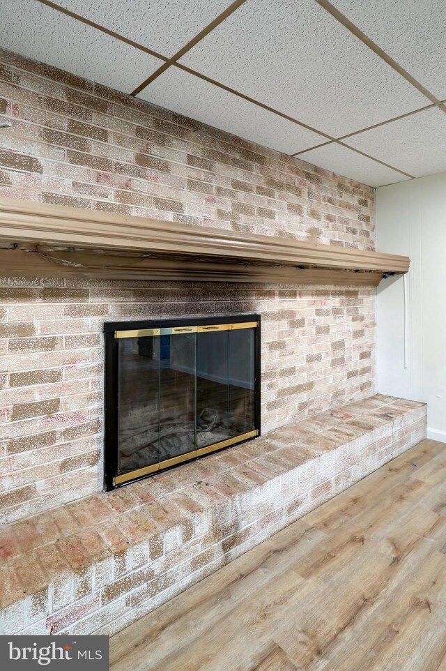 809 N Arch St, Mechanicsburg, PA 17055 - detailed view of wood finished floors, a brick fireplace, a paneled ceiling, and brick wall