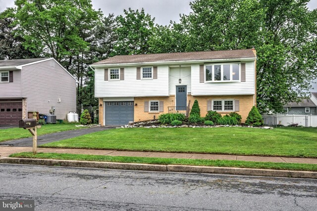809 N Arch St, Mechanicsburg, PA 17055 - bi-level home with driveway, brick siding, a chimney, central air condition unit, and a garage